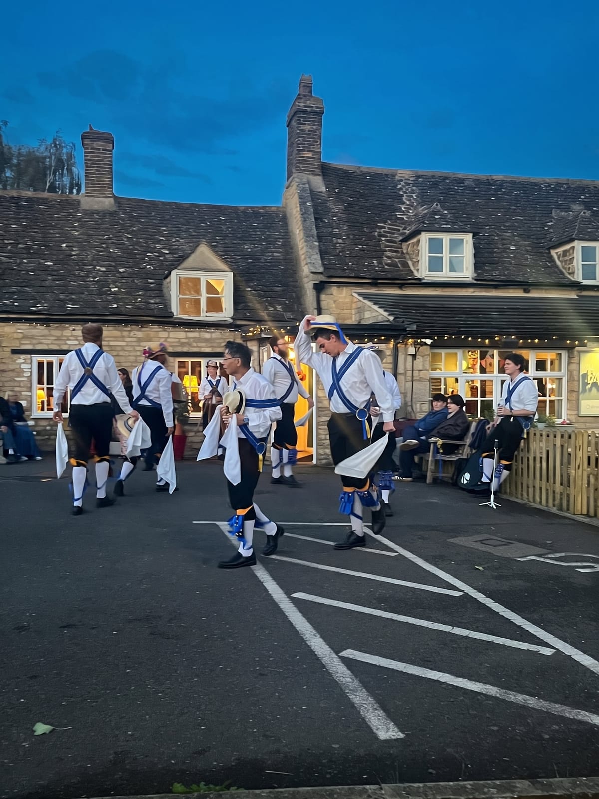 Morris dancers in front of the pub at dusk