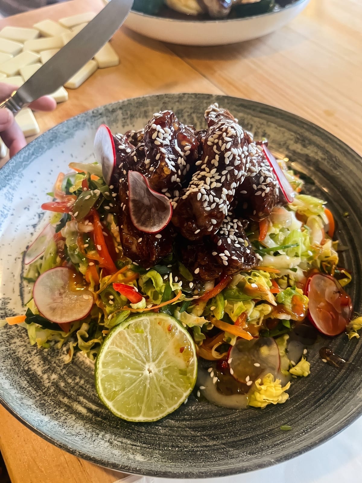 A glazed main course on slaw with radish and lime